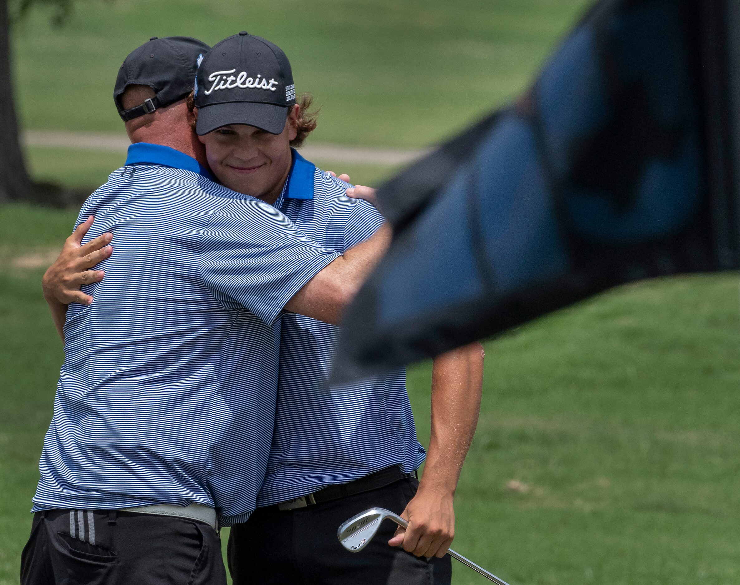 Plano West Matt Comegys gets a hug from his coach, Joe Cravens after chipping in on the 18th...