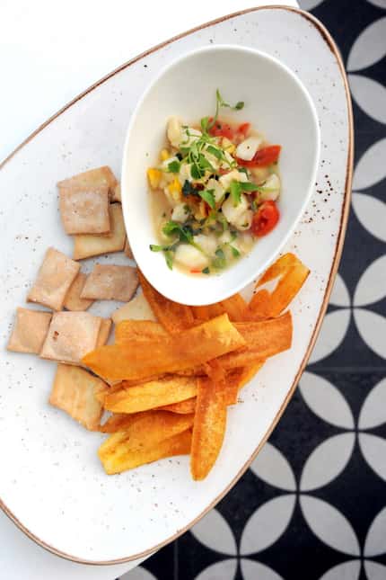 Ceviche De Mariscos is made with Chilean sea bass, corn, tomato and avocado and served with...