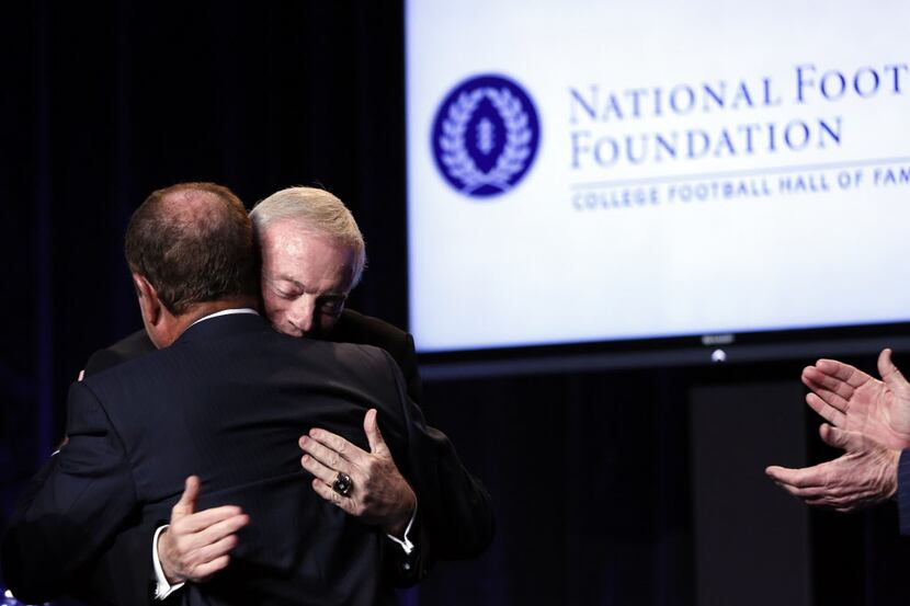 Jerry Jones hugs a panel member at the end of his speach during National Football Foundation...