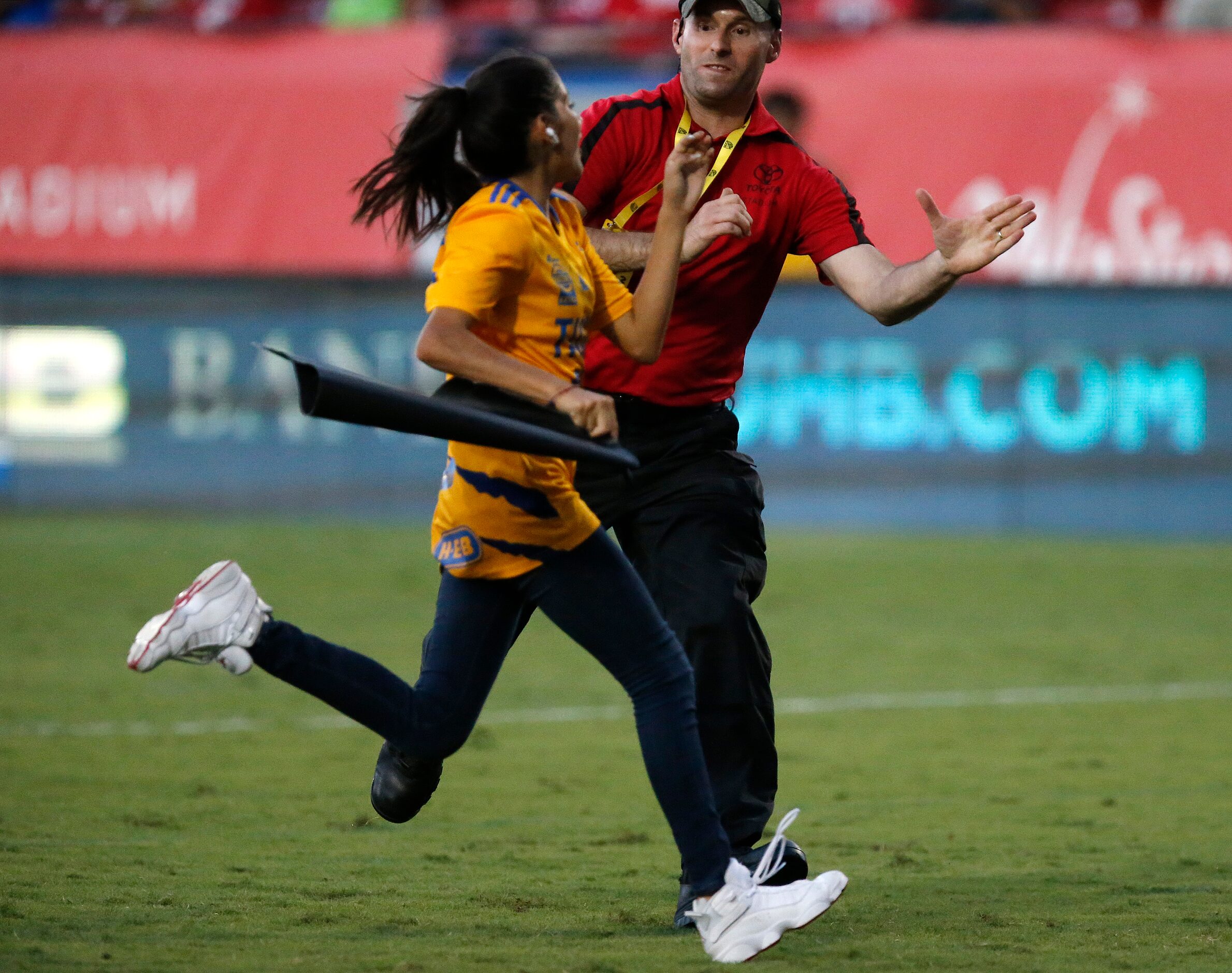 Stadium security runs down a Tigres UNAL fand seeding an autograph on the pitch during the...