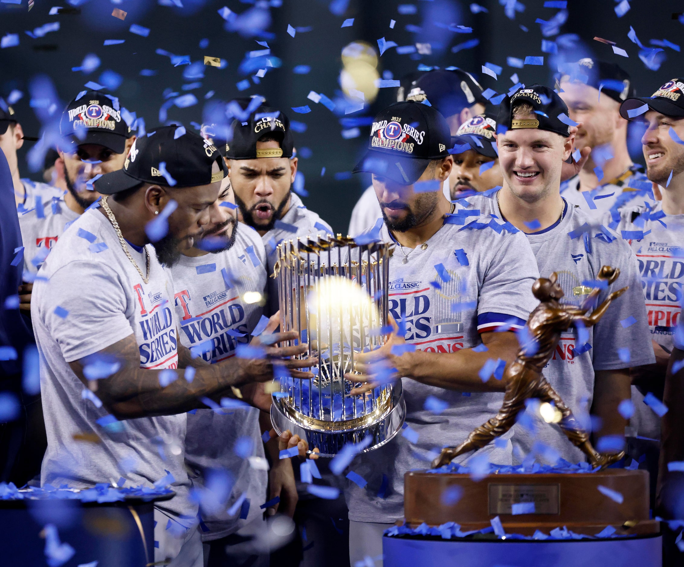 With confetti racing down, Texas Rangers Adolis Garcia (left) checks out the World Series...