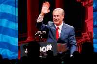 Texas Gov. Greg Abbott is seen on a big screen as he waves during the Leadership Forum at...