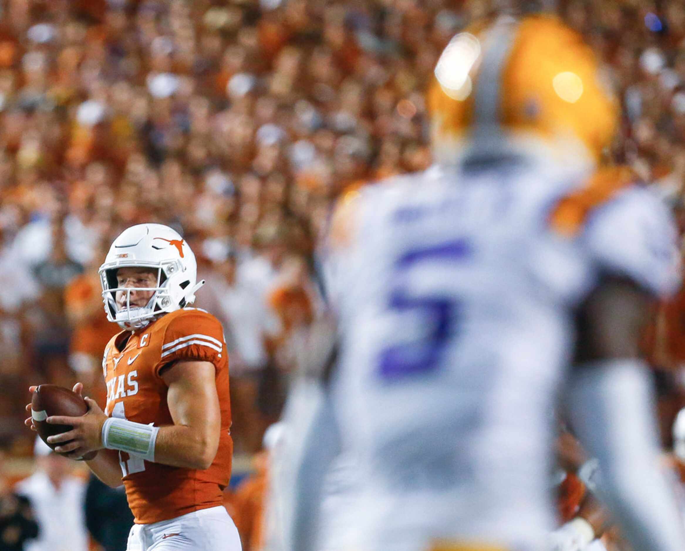 Texas Longhorns quarterback Sam Ehlinger (11) looks for a receiver a college football game...