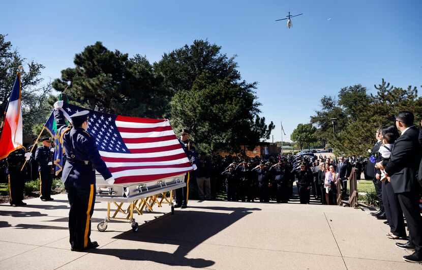The Dallas Police helicopter performs a flyover as the U.s. flag is presented above the...