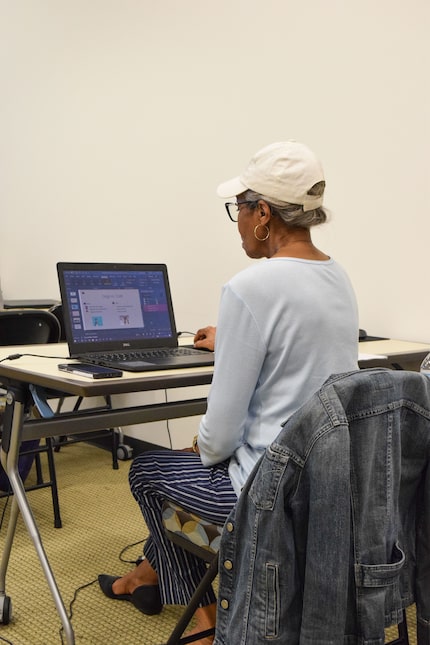 Woman sitting at a table working on a laptop