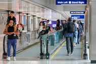 Passengers walk between gates at Terminal D at DFW Airport on Sunday, Oct. 29, 2023.