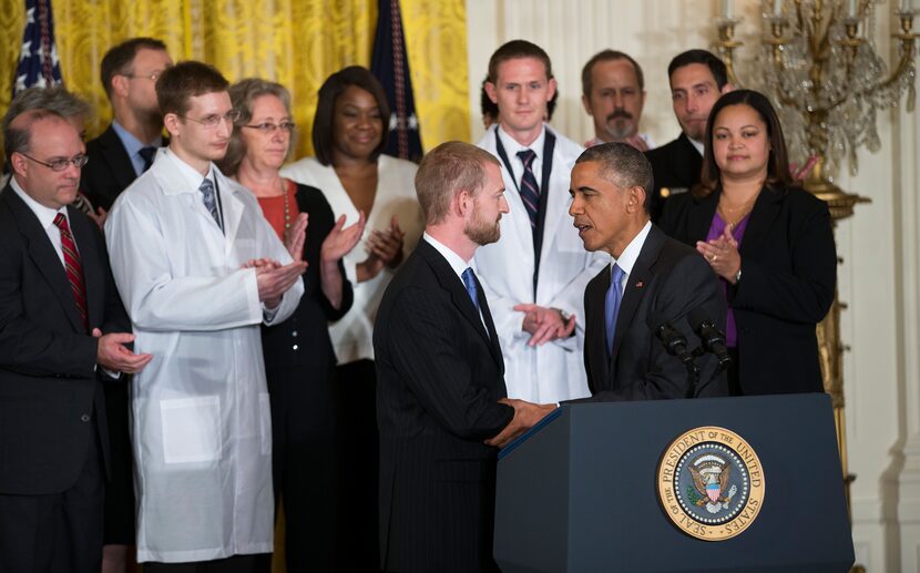 President Barack Obama shakes hands with Ebola survivor Dr. Kent Brantly during an event...