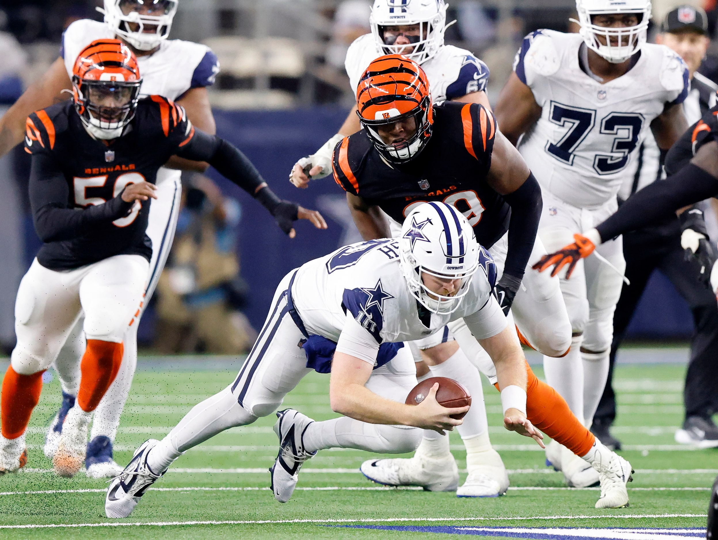 Dallas Cowboys quarterback Cooper Rush (10) stumbles and falls as he’s pushed down by...