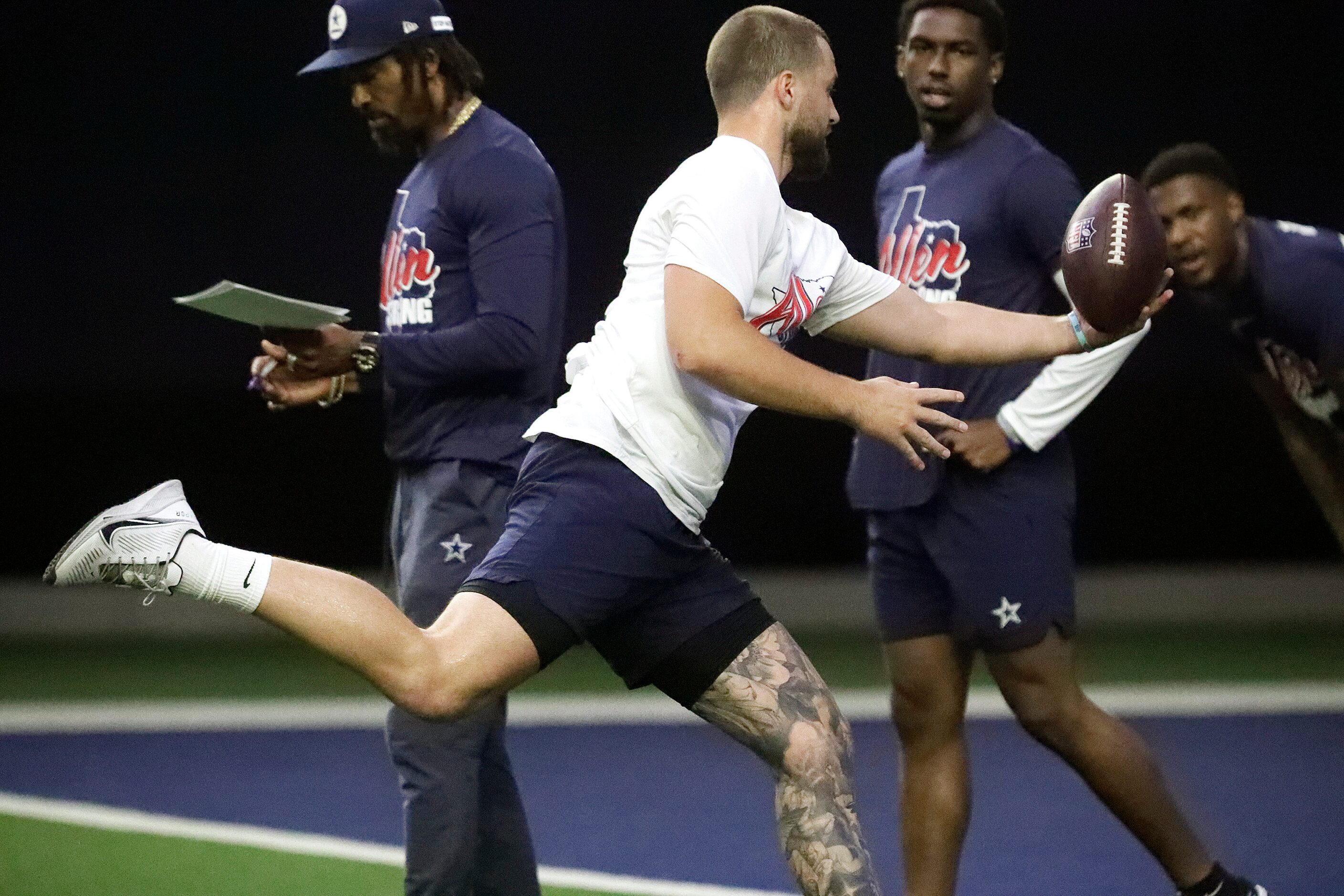 Tight end Jake Ferguson hangs onto a catch while running plays as the Dallas Cowboys held...