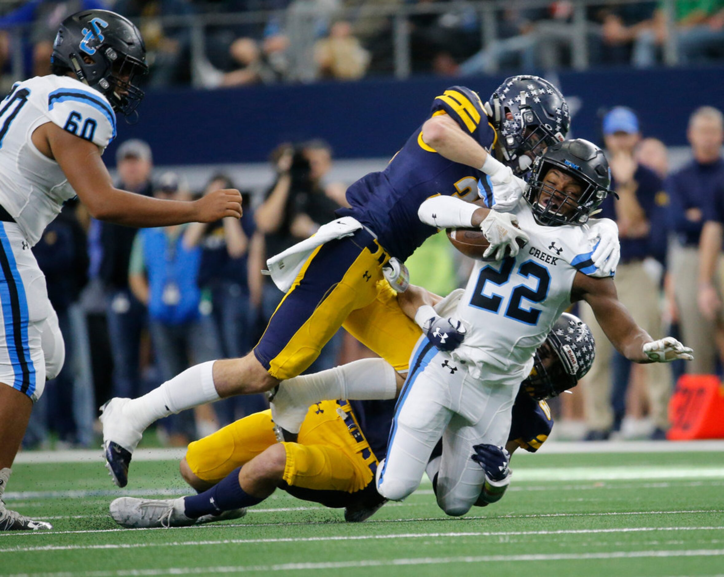 Highland Park's  Brock Bakich (35) and Saunders Wood (64) tackle Shadow Creek's running back...