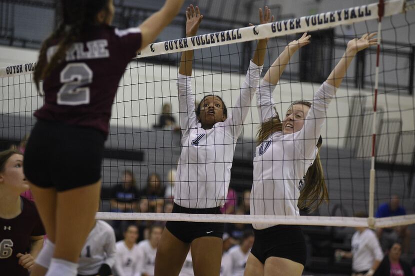 Guyer volleyball players Jordyn Williams (7) and Shea Slusser (10) attempt to defend aginst...