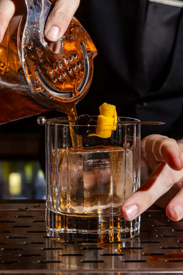Bartender Jacob Claiborne prepares a Duck Old Fashioned, duck fat-washed Garrison Bros small...