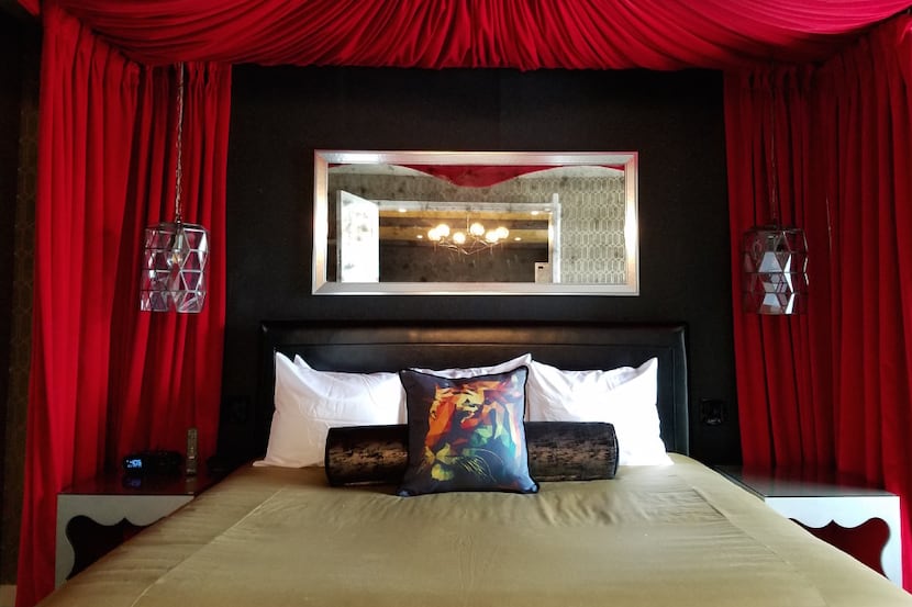 The King Suite at The Guest House at Graceland has two bedrooms, with beds draped in red...