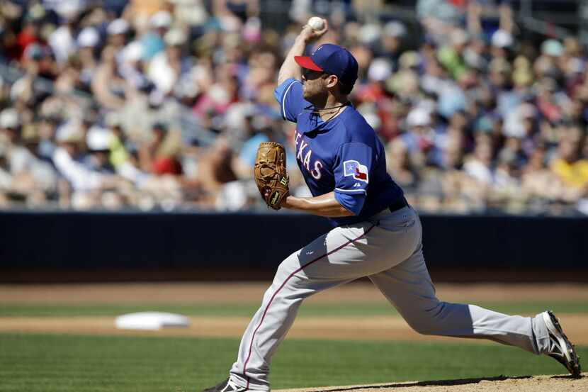 Texas Rangers starting pitcher Colby Lewis throws during the first inning of an exhibition...