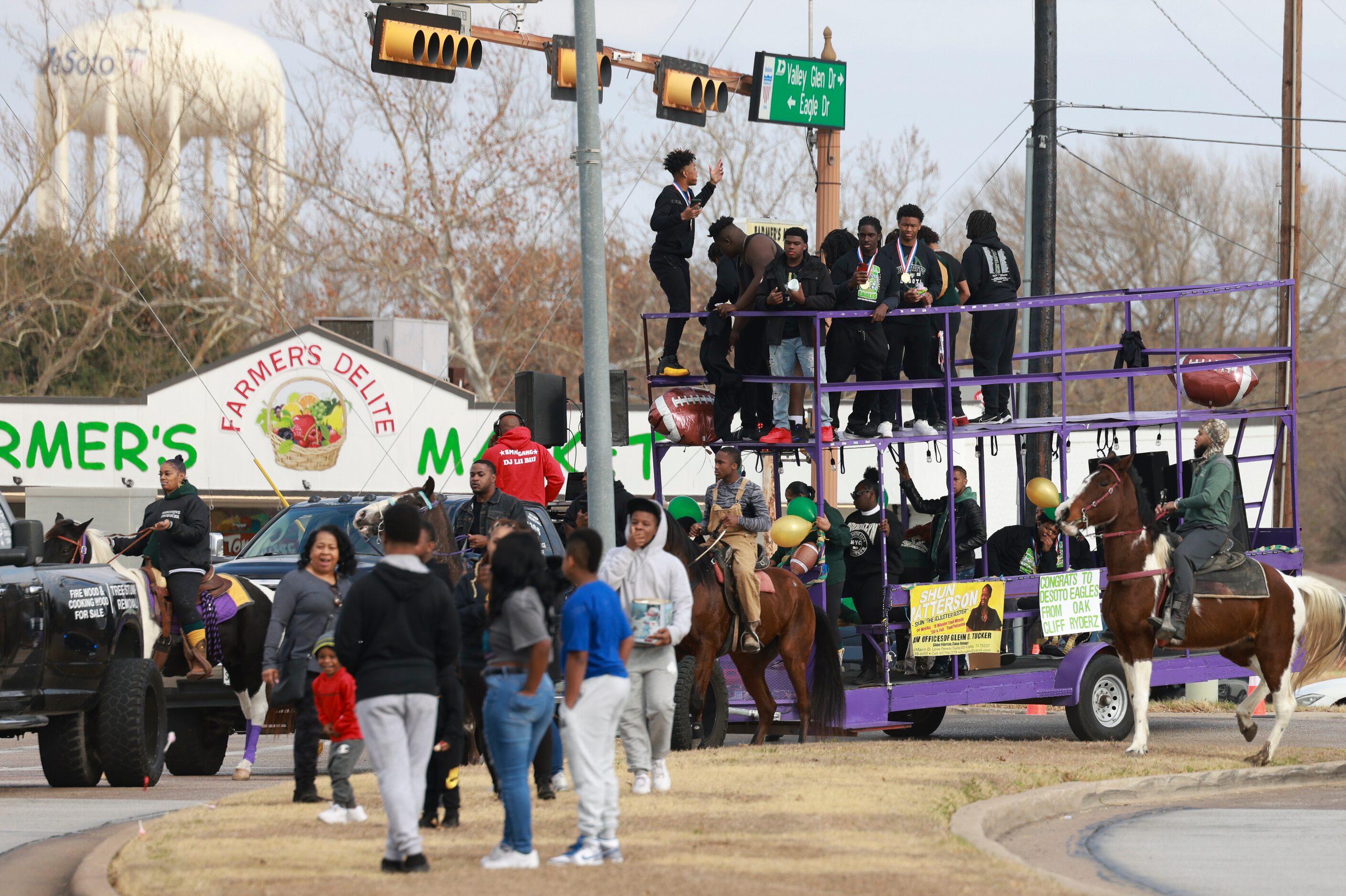 DeSoto High School football players ride on top of a double-decker trailer, Saturday, Jan....