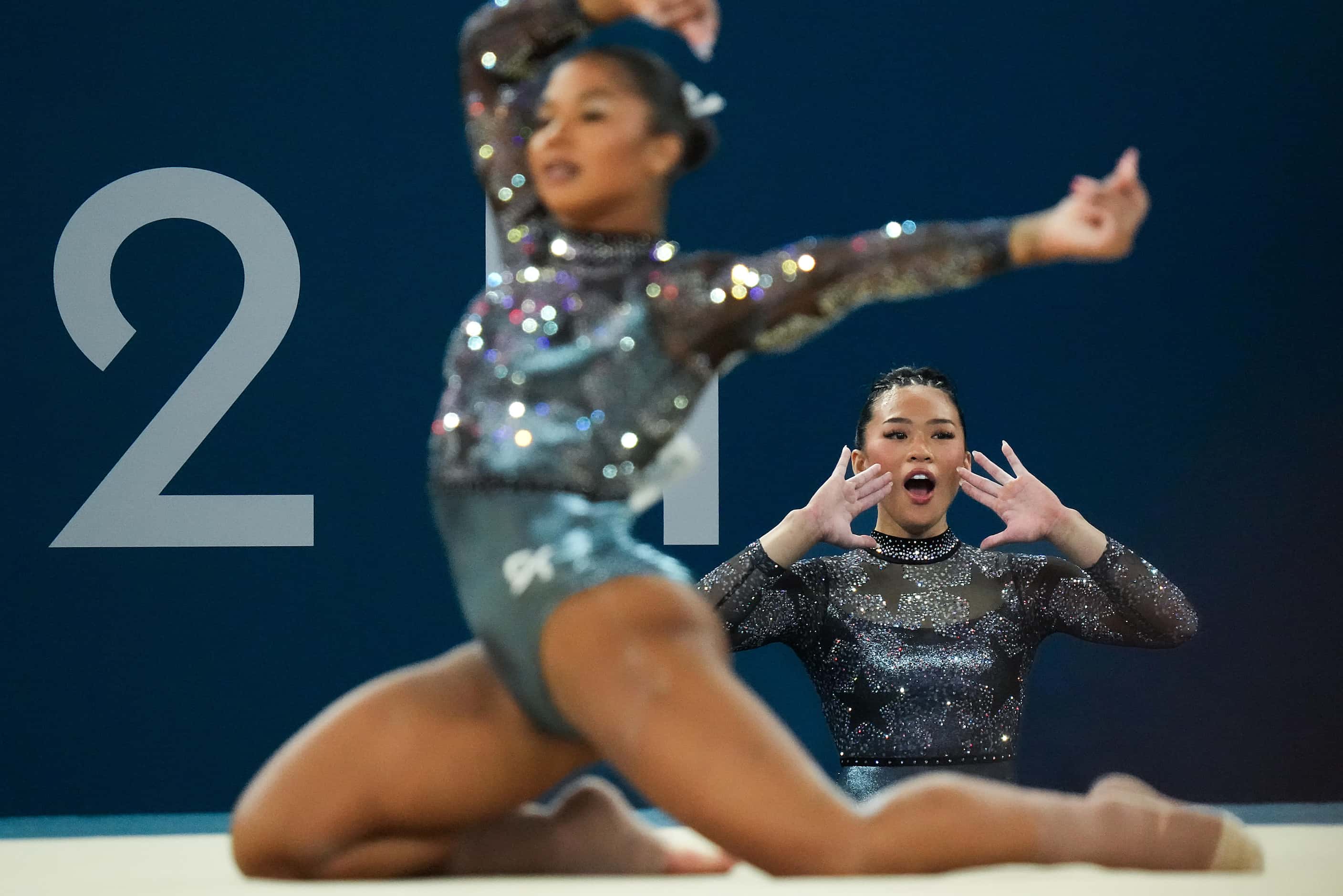 Suni Lee of the United States cheers teammates Jordan Chiles as she competes on the floor...