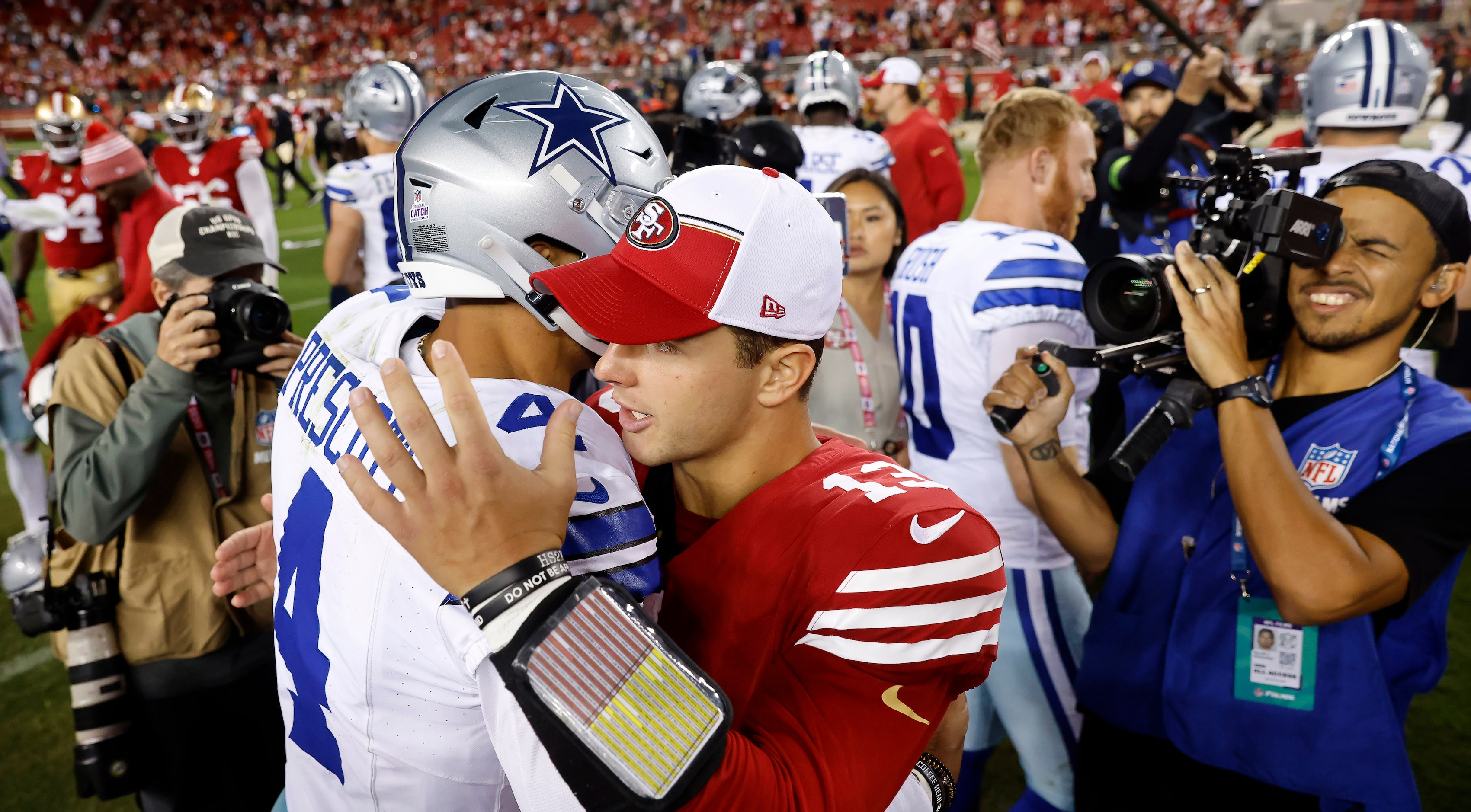 Dallas Cowboys quarterback Dak Prescott (4) gives a congratulatory hug to San Francisco...