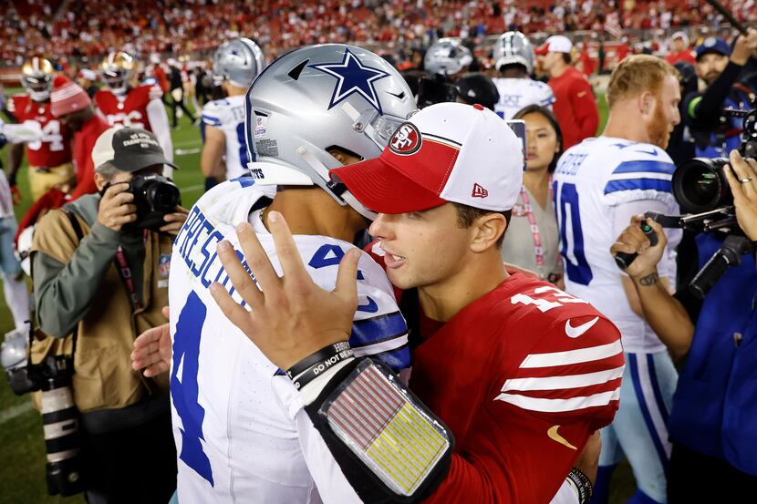 Dallas Cowboys quarterback Dak Prescott (4) gives a congratulatory hug to San Francisco...