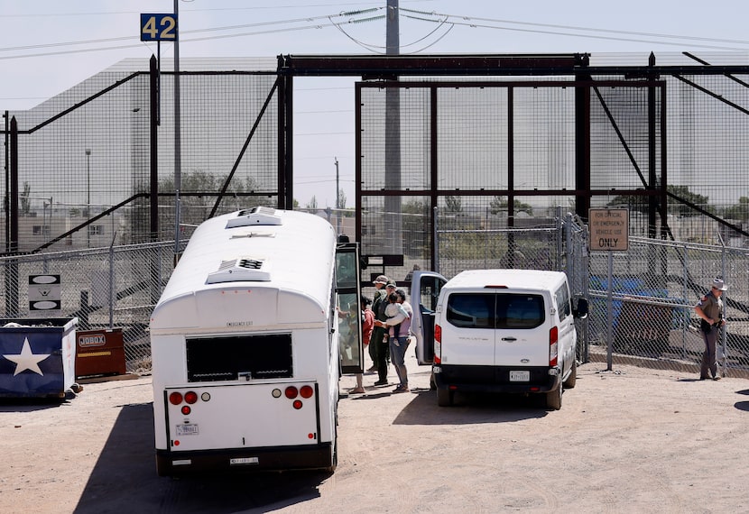 Migrant people board a waiting bus after settling on the U.S. side of the Rio Grande River,...