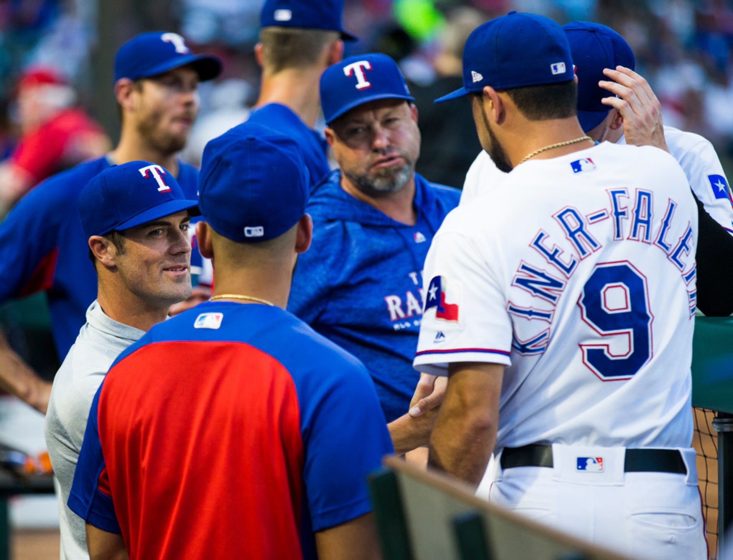 Texas Rangers starting pitcher Cole Hamels (35, left) gets handshakes from team mates in the...