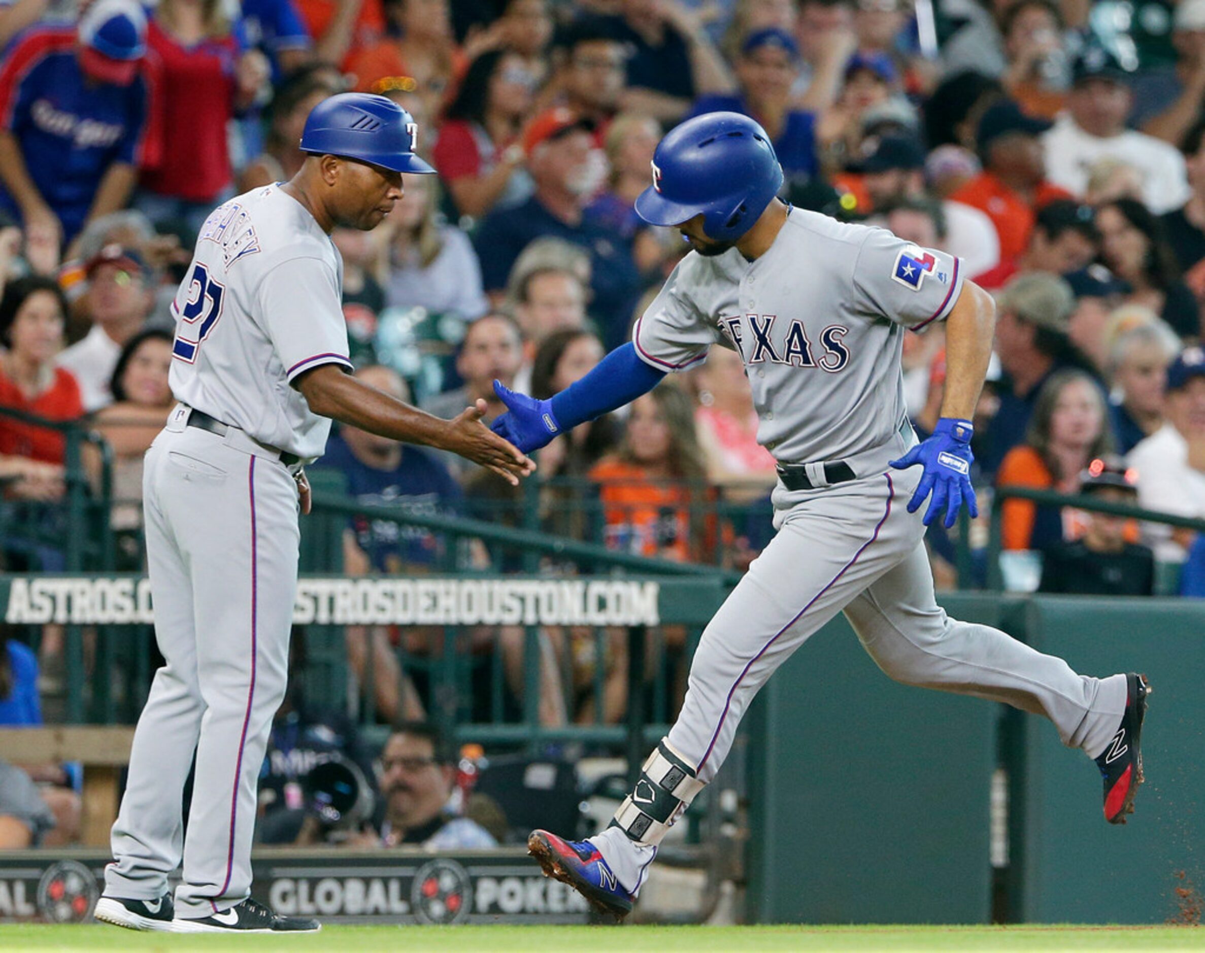 Texas Rangers third base coach Tony Beasley (27) congratulates Isiah Kiner-Falefa who rounds...