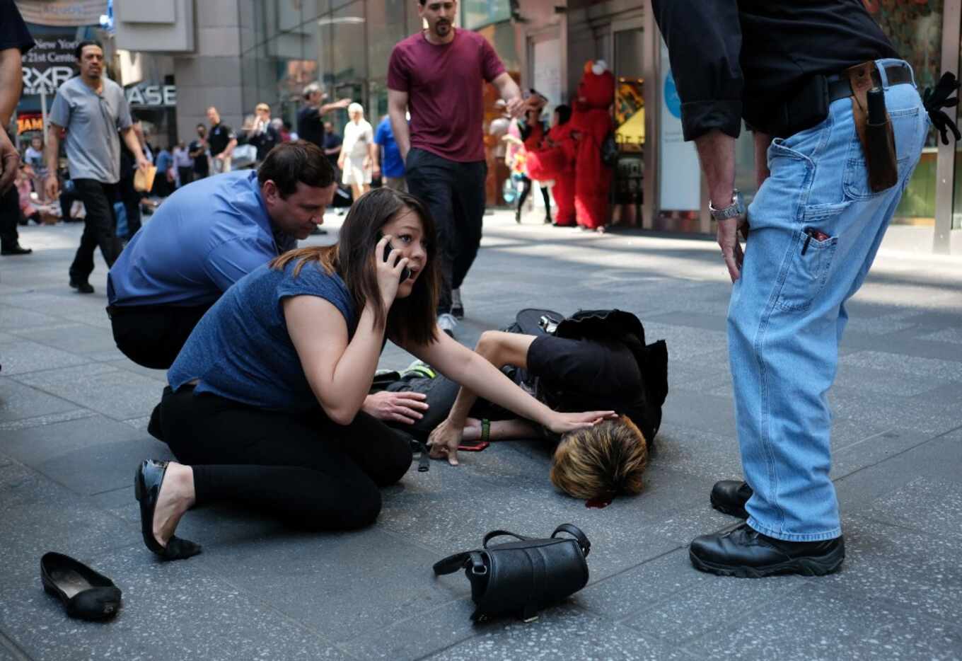People attend to an injured man after a car hit him in Times Square.