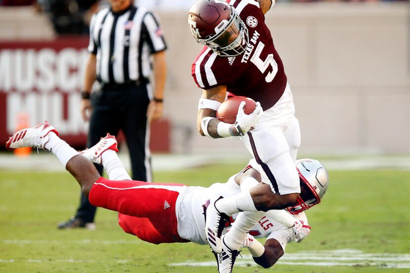 Texas A&M Aggies running back Trayveon Williams (5) is tripped up by Nicholls State Colonels...