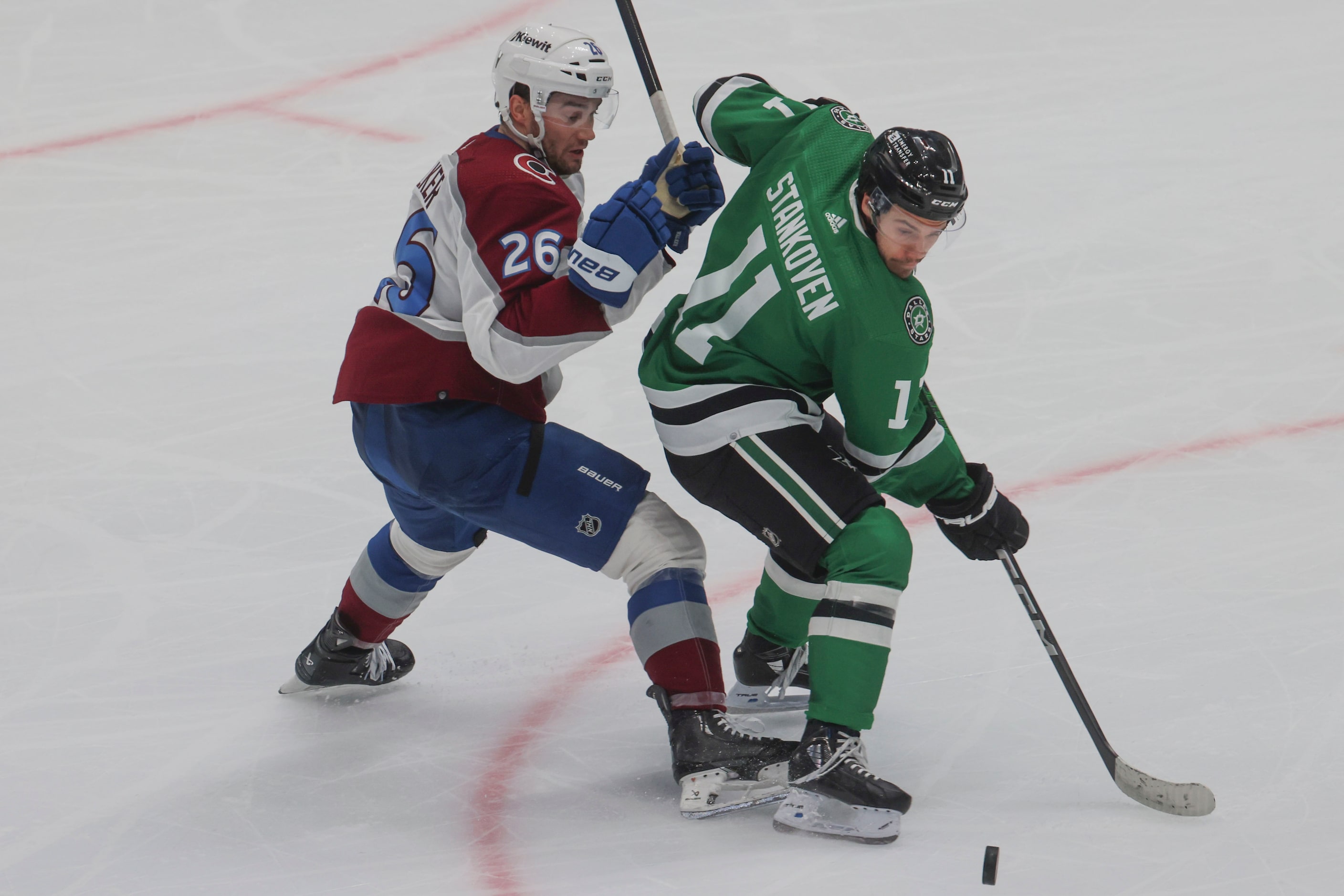 Dallas Stars center Logan Stankoven (right) controls the puck against Colorado Avalanche...