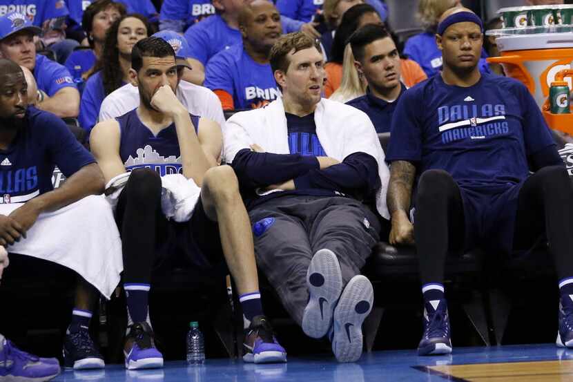 Dallas Mavericks forward Dirk Nowitzki, center, and fellow Mavericks watch from the bench...
