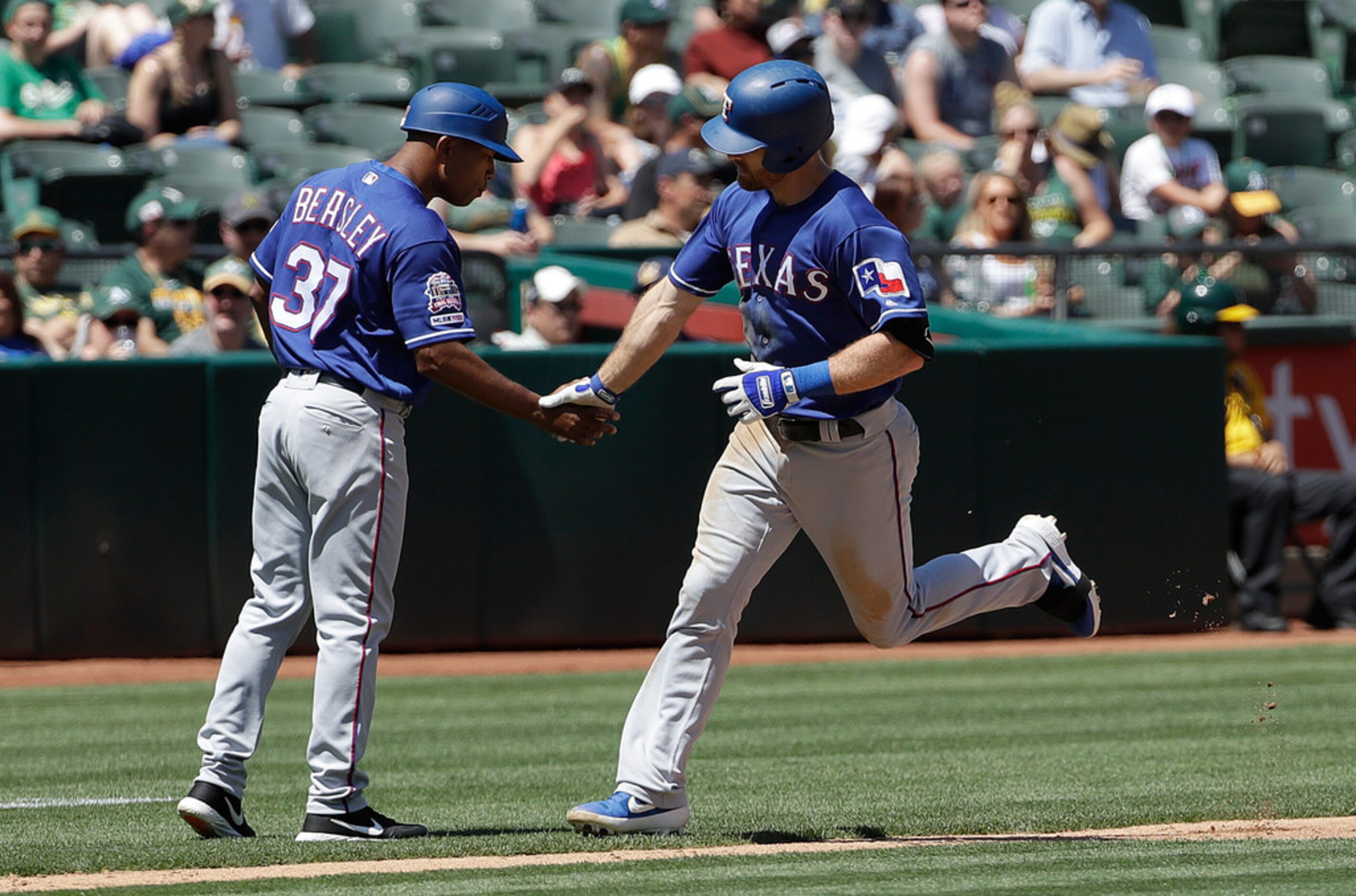 Texas Rangers' Logan Forsythe, right, is congratulated by third base coach Tony Beasley...