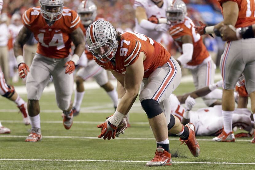 Ohio State defensive lineman Joey Bosa (97) recovers a fumble before running it back for a...