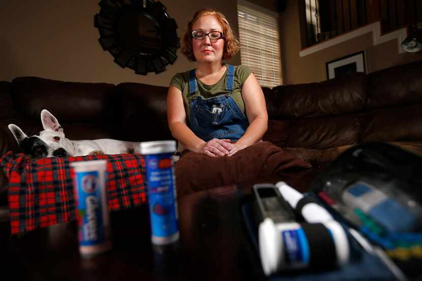 Kelli Bennett, a dog walker, poses for a photograph with her glucose tablets and insulins at...