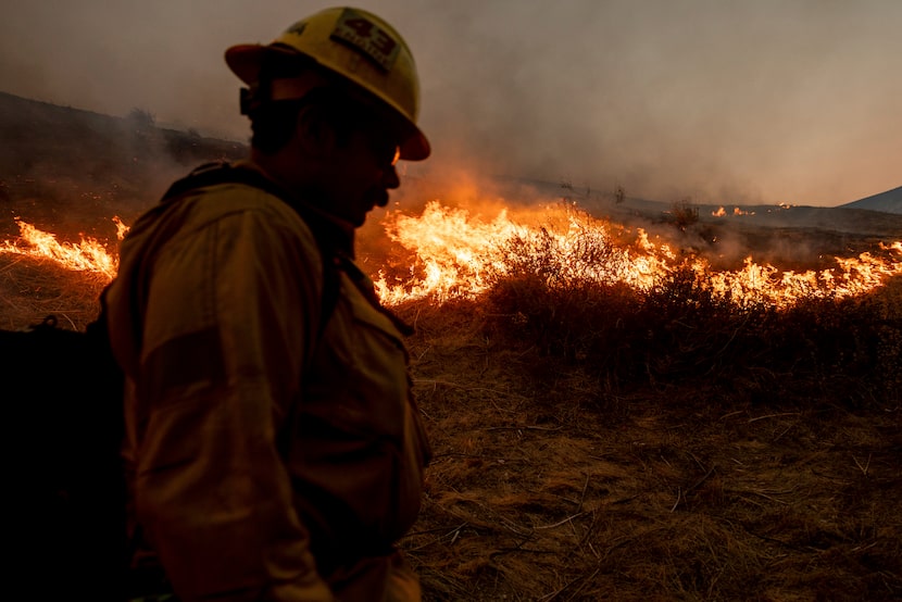 A firefighter monitors the advance of the Kenneth Fire in the West Hills section of Los...