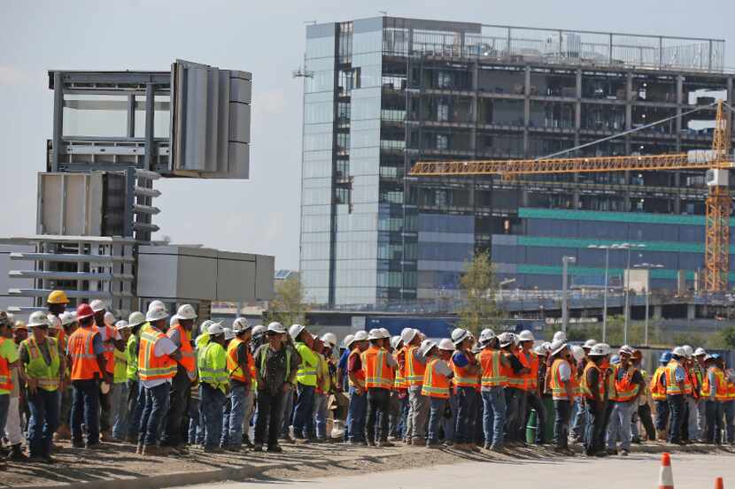 Construction workers gather to view the festivities during a ceremony to celebrate the...
