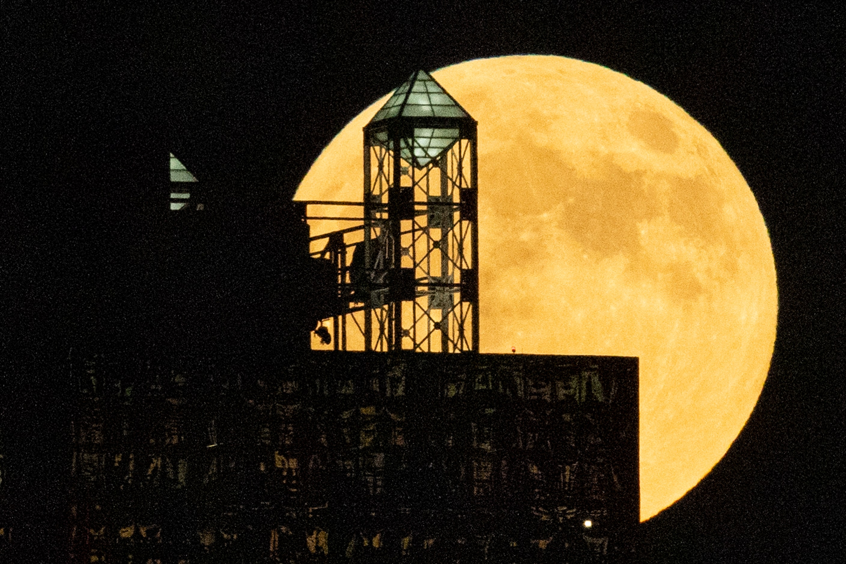 A partial lunar eclipse and supermoon is seen over Renaissance Tower in downtown Dallas,...