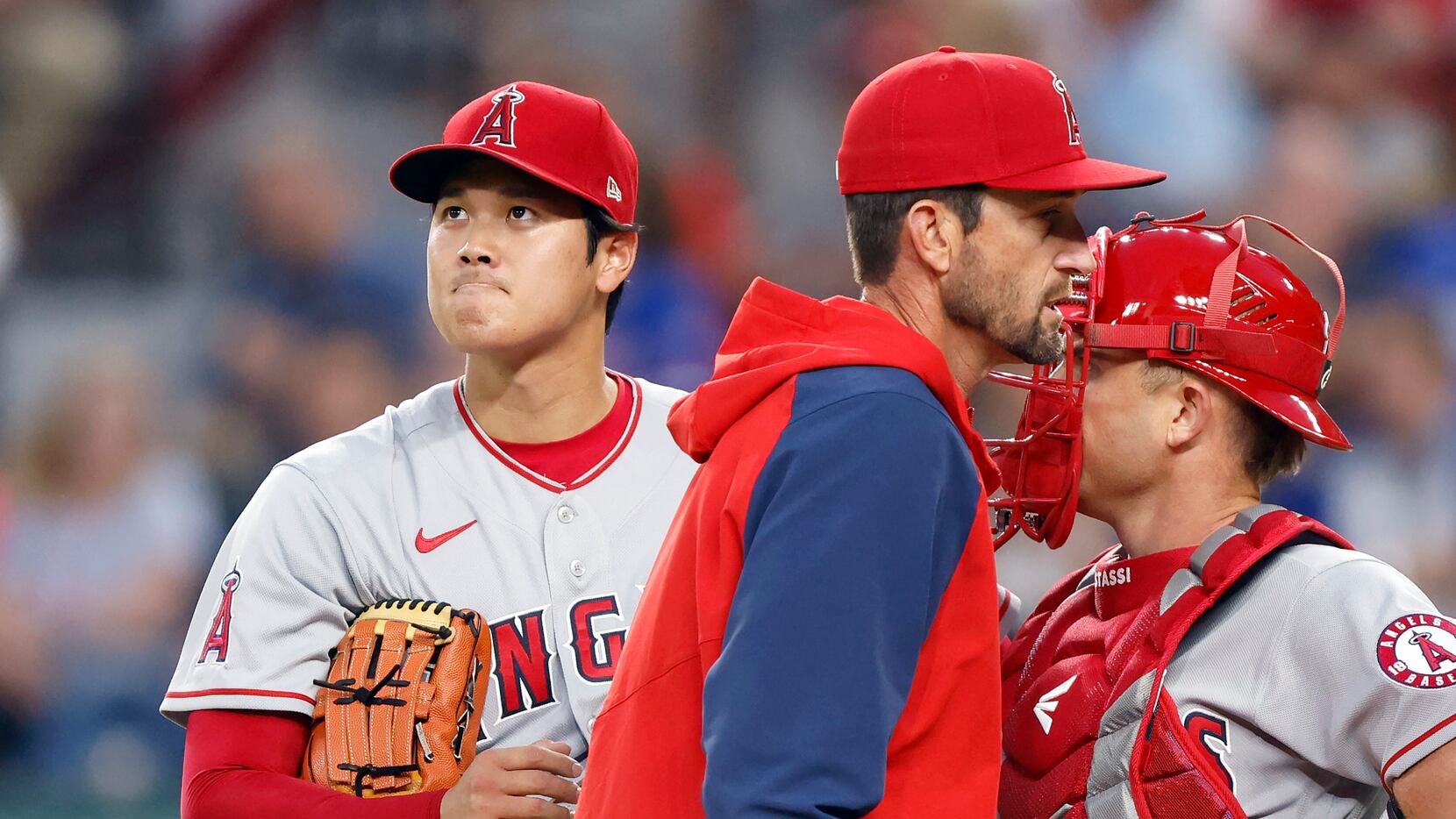 Los Angeles Angels starting pitcher Shohei Ohtani (left) reacts after receiving a visit to...