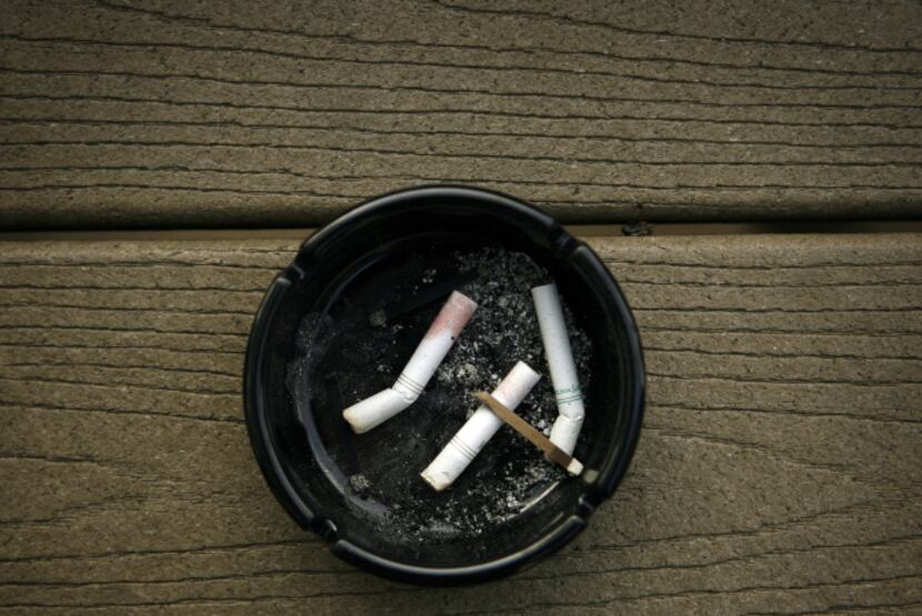 An butt and match filled ashtray sits on patio seating outside Lakewood Landing April 10,...