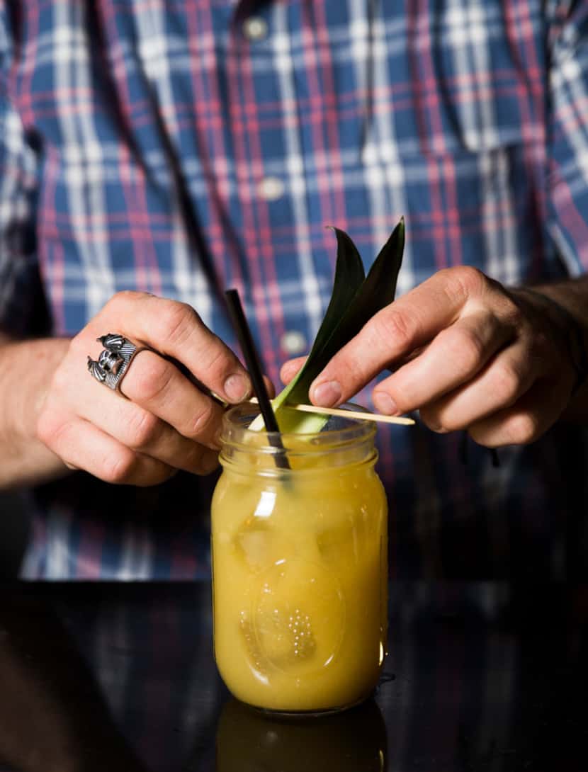 Bartender Chris Dempsey garnishes house-made tepache at Las Almas Rotas in Dallas. 