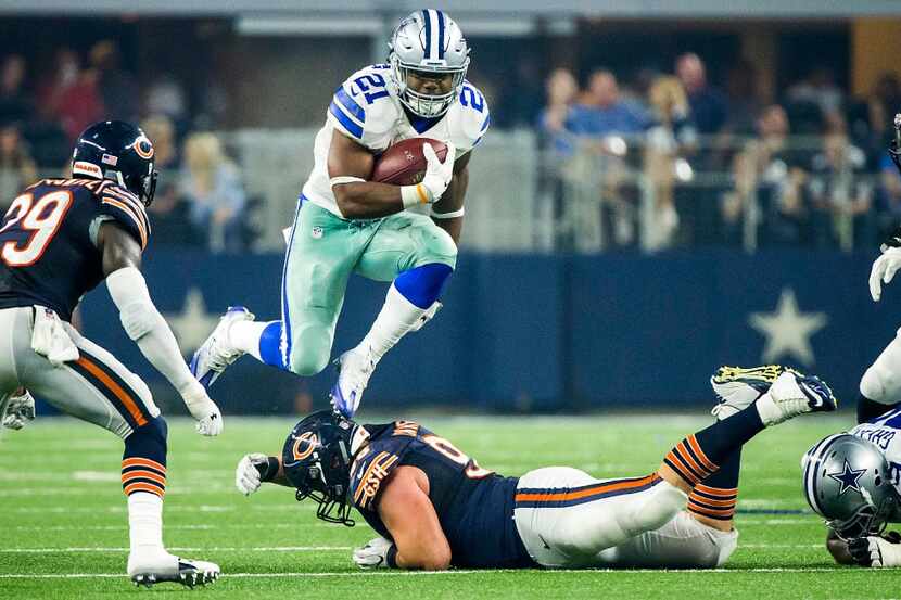 Dallas Cowboys running back Ezekiel Elliott (21) leaps over Chicago Bears defensive end...