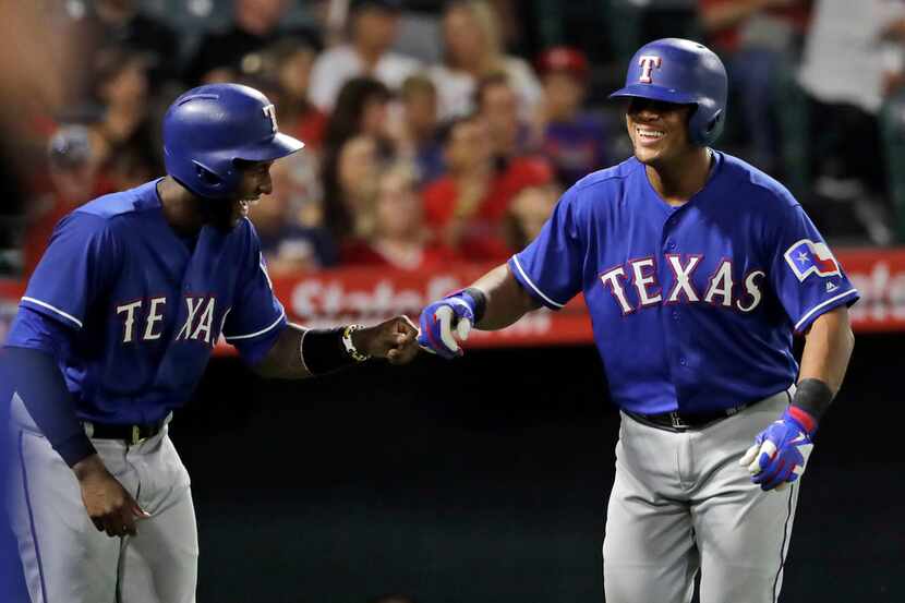 Texas Rangers' Jurickson Profar, left, and Adrian Beltre celebrate as they were both driven...