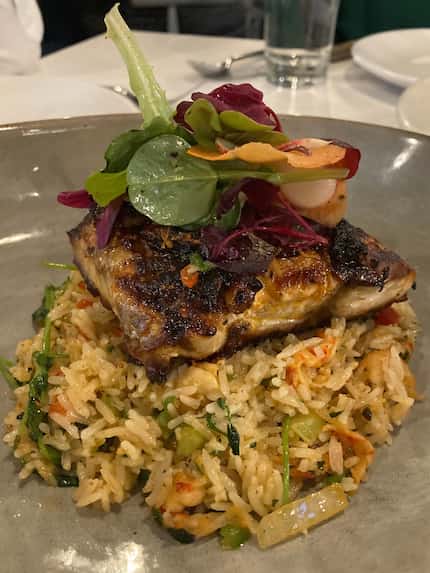 The Texas redfish at Roots Southern Table is first grilled, then baked and rubbed in a...