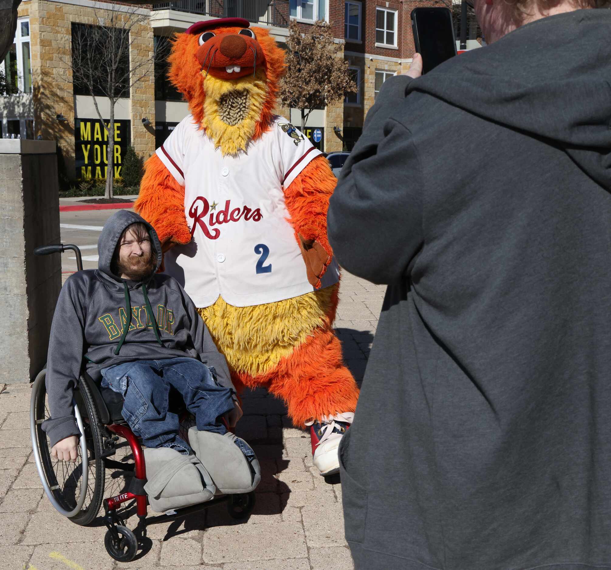 Texas Rangers fan Jacob Fry poses with a photo with Frisco RoughRiders mascot "Deuce"...