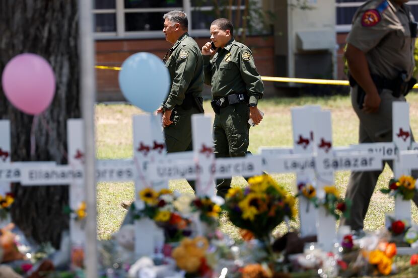 Border Patrol agents walk around a memorial before a Texas Department of Public Safety press...