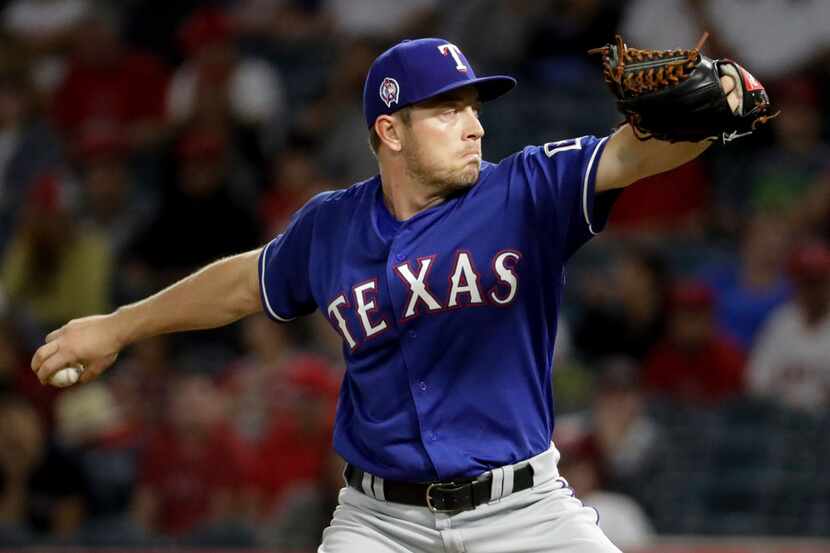 Texas Rangers starting pitcher Adrian Sampson throws against the Los Angeles Angels during...