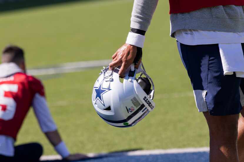 Dallas Cowboys quarterback Dak Prescott (4) holds his helmet with his right hand during the...