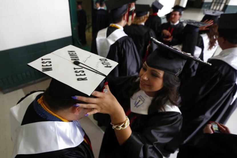 West High graduate Andy Ward has his hat adjusted by classmate Karen Tamayo. His hat...
