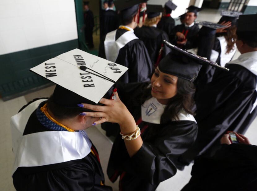 West High graduate Andy Ward has his hat adjusted by classmate Karen Tamayo. His hat...