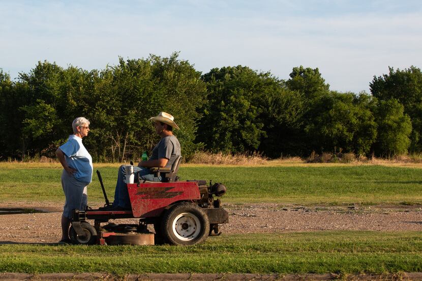 Locals Denise Spencer (left) and Bruce Aaron chat in evening light in Cooper, Texas, on...