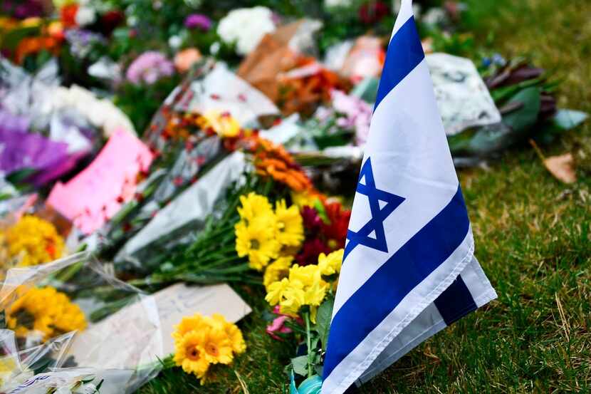 An Israeli national flag is seen at a memorial on October 28, 2018, down the road from the...