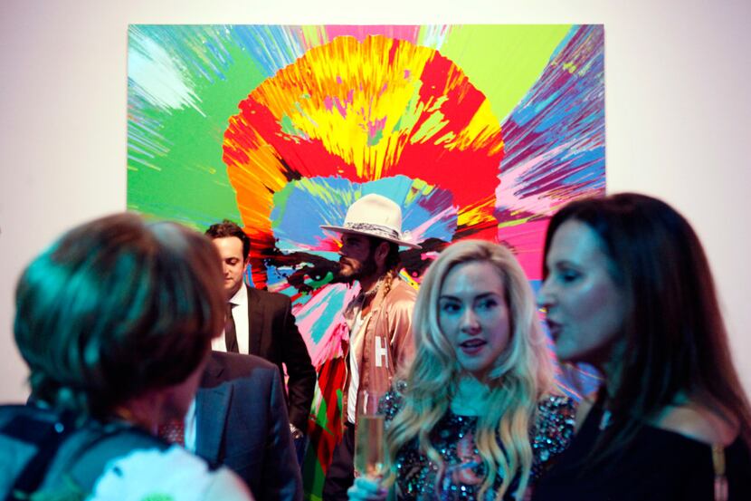 Hair designer Charlie Price, in a hat, is photographed in front of a painting of George...